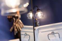 Light fixture shot ; detail shot from bathroom remodeling project photo gallery.  Features Custom casings and hand-made rosettes, tone-on-tone floor tile, vintage-inspired lighting and classic chrome plumbing fixtures.