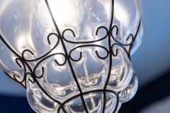 Light fixture close-up ; detail shot from bathroom remodeling project photo gallery.  Features Custom casings and hand-made rosettes, tone-on-tone floor tile, vintage-inspired lighting and classic chrome plumbing fixtures.