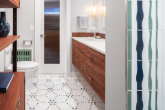 Basement bathroom refresh, fun tile, double sink, built in shower storage, and seafoam green bathtub. Bright and fun basement bathroom.