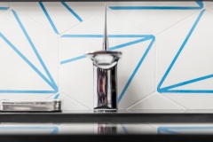Sink faucet, geometri wall tile ; detail shot from modern bathroom remodel with cerulean blue floor tiles and geometric shower floor.   Features polished chrome fixtures and retro atomic-age light fixtures.