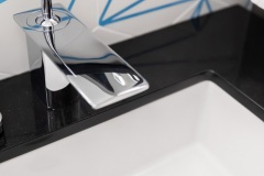 Faucet and sink close-up ; detail shot from modern bathroom remodel with cerulean blue floor tiles and geometric shower floor.   Features polished chrome fixtures and retro atomic-age light fixtures.