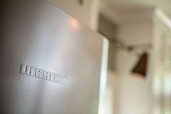 Liebherr fridge brand name close-up , detail image, part of modern kitchen remodel photo gallery. Remodel features custom cabinetry.  