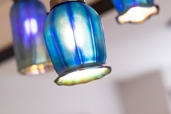 Blue hanging flower light fixture close-up ; part of transitional design kitchen remodel in Minneapolis 4-square home.   Features  modern textures and colors, reused and recreated historical details, colorful backsplash and kitchen island.
