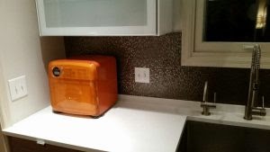 small half-pint orange microwave in corner on kitchen counter