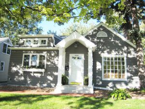 A grey home with green grass