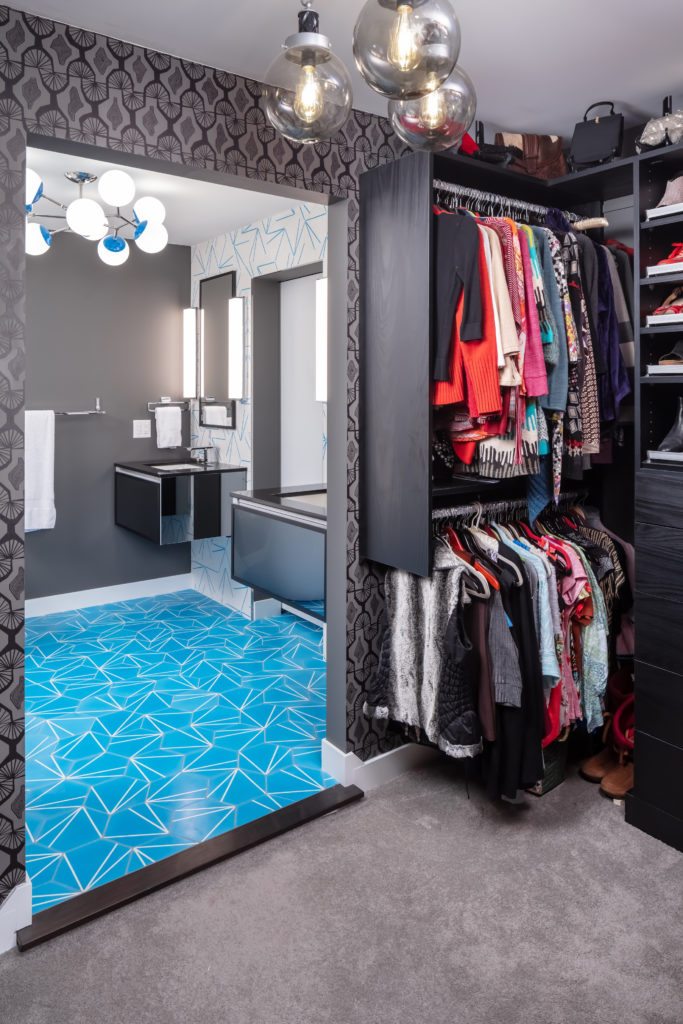 Mid-Century Moxie: A Master Bath Makeover. Modern bathroom remodel with cerulean blue floor tiles and geometric shower floor. Features polished chrome fixtures and double vanity.