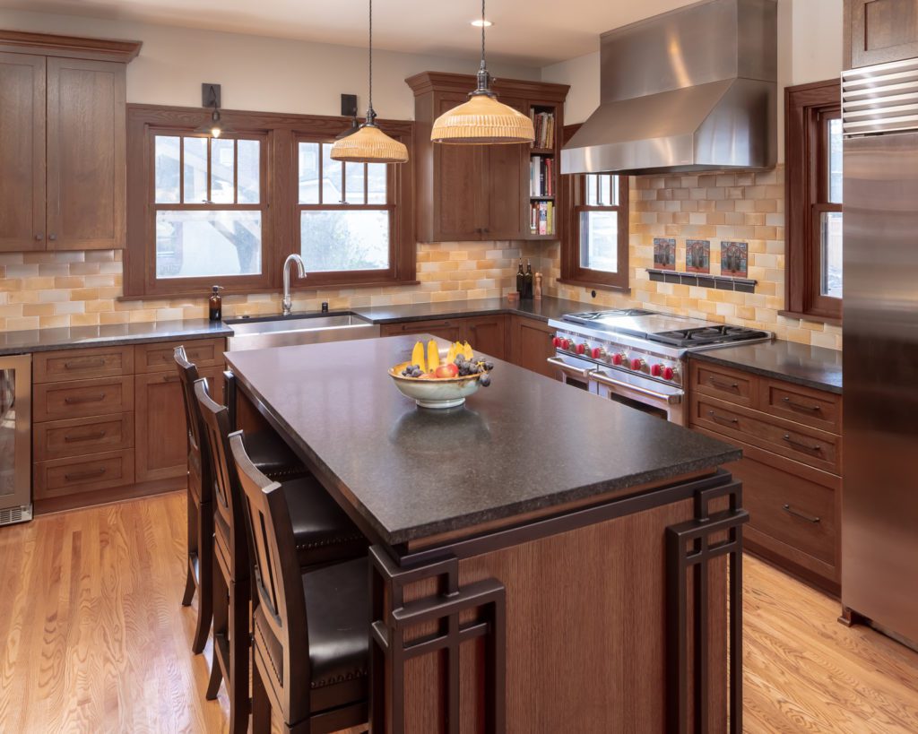 Modern Elegance Meets Historic Charm: Craftsman style kitchen remodel. Features large square island and L-shaped plan; melds elegance and function into historic architecture. 