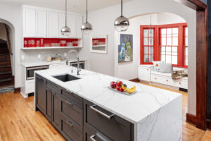 Bluestem modern Kitchen with white island, built in storage, bright red accents