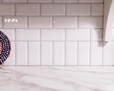 Bluestem Kitchen: White porcelian tile backsplah with marble countertop