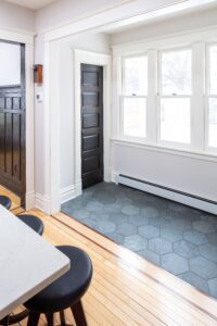 Bluestem mudroom off of kitchen. Blue tile flooring, windows.