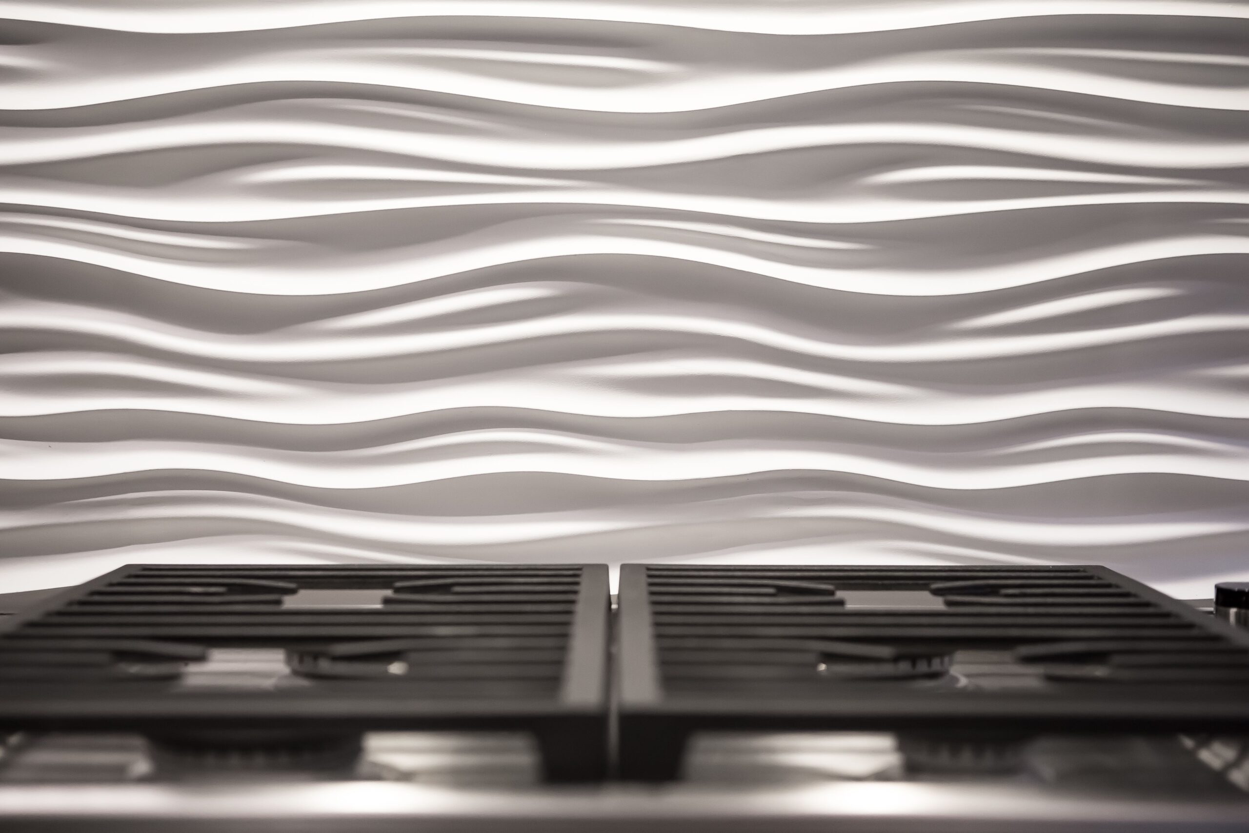 Twin Cities remodeled kitchen blacksplash. White wavy designed backsplash above a stove