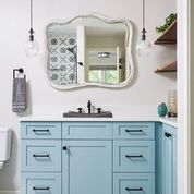 light blue cabinets in a bright, basement bathroom.