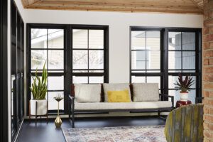 inside 3-Season Screen Porch Addition, view of sofa, plants and out windows