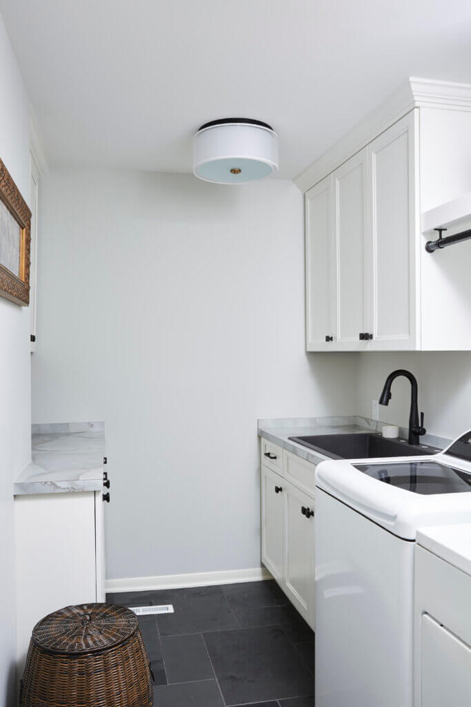 White laundry room with a white washer and dryer.