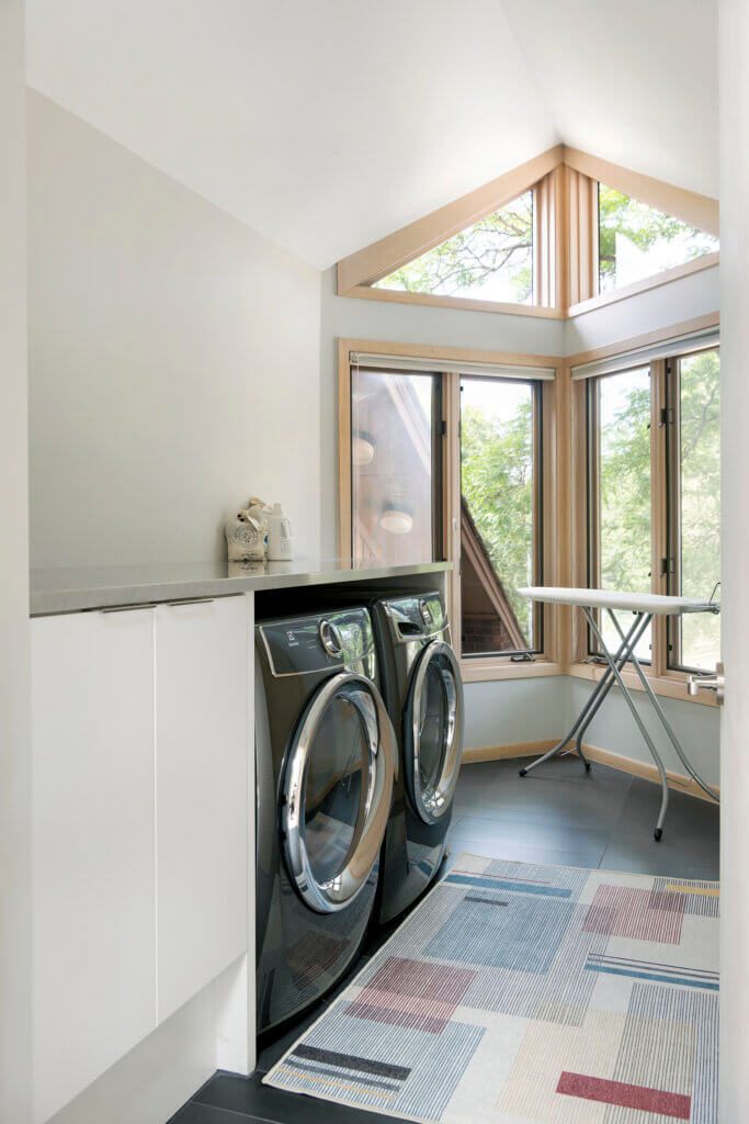 Laundry room with bright natural light and black appliances.