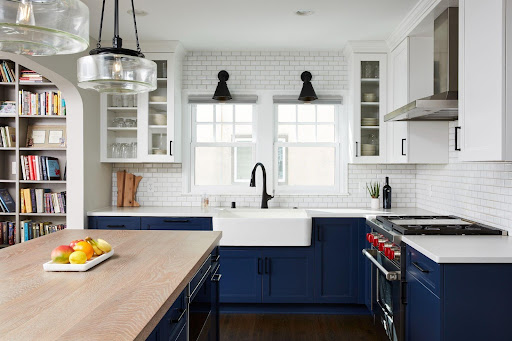 Kitchen remodel with white features and navy blue cabinetry.