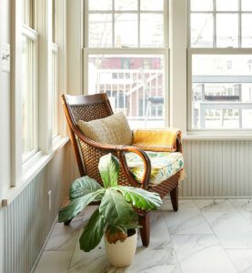 chair on sunny 4-season screen porch in corner next to window, plant next to chair