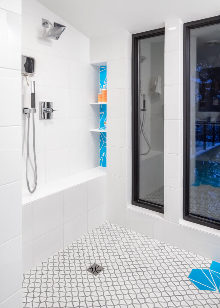 Bathroom with doorless shower. Windows, blue accent tiles.