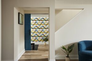 Basement with blue sliding barn door slightly ajar to reveal multicolored wall paper