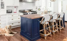 Luxury kitchen remodel and kitchen addition in colonial home. Traditional style, features island, butler's pantry, custom royal blue cabinetry and added family room. Dog in photo lying on floor next to island.